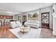 Sun-filled living room with comfortable seating, hardwood floors and view into the kitchen at 10887 Endeavor Dr, Parker, CO 80134