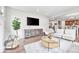 Comfortable living room with large TV, fireplace, hardwood floors, and an open floor plan at 10887 Endeavor Dr, Parker, CO 80134