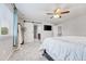 Bright main bedroom with a walk-in closet, tv, and ceiling fan with hardwood floors at 10887 Endeavor Dr, Parker, CO 80134