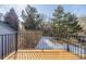 Inviting outdoor space featuring a wood deck with metal railings, surrounded by mature trees and snow covered yard at 364 Willowick Cir, Highlands Ranch, CO 80129