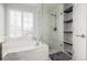 Bathroom featuring soaking tub, glass enclosed shower, storage shelves, and a bright window at 364 Willowick Cir, Highlands Ranch, CO 80129