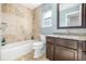 Bathroom featuring tiled bathtub, toilet, vanity, granite counter, and mirror at 364 Willowick Cir, Highlands Ranch, CO 80129