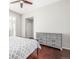 A bedroom with a ceiling fan, a dresser, wood flooring, and a bed with gray and white patterned comforter at 364 Willowick Cir, Highlands Ranch, CO 80129