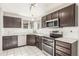 This kitchen features stainless steel appliances, dark wood cabinets, modern countertops, and white tiled backsplash at 364 Willowick Cir, Highlands Ranch, CO 80129