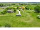 Wide aerial view of sprawling grassy property with home and outbuildings on a sunny day at 15545 Lipan St, Broomfield, CO 80023