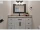 Stylish half-bathroom with white cabinets, marble countertops, and a modern black framed mirror at 15545 Lipan St, Broomfield, CO 80023
