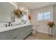 Bright bathroom with a dual sink vanity, contemporary mirrors, and stylish floral decor at 15545 Lipan St, Broomfield, CO 80023