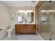 Bright bathroom featuring double vanity with wood cabinets, marble floors, and glass-enclosed shower at 15545 Lipan St, Broomfield, CO 80023