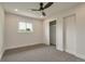 A simply decorated bedroom offers a closet and a window with treetop views at 15545 Lipan St, Broomfield, CO 80023