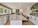Spacious kitchen island with marble countertop, seating, and stylish backsplash at 15545 Lipan St, Broomfield, CO 80023