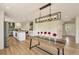 Bright, open-concept kitchen and dining area featuring modern lighting and a long, wooden table at 15545 Lipan St, Broomfield, CO 80023