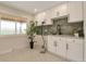 Bright laundry room featuring white cabinets, quartz countertop and modern fixtures at 15545 Lipan St, Broomfield, CO 80023