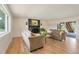 Bright living room with a fireplace, hardwood floors, and a view of the outdoor landscape at 15545 Lipan St, Broomfield, CO 80023