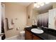 Clean bathroom with vanity, toilet, shower and black countertop at 9711 W Indore Dr, Littleton, CO 80128