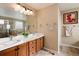 Elegant bathroom with double vanity, large mirror, and walk-in shower at 9711 W Indore Dr, Littleton, CO 80128