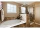 Relaxing bathroom featuring a soaking tub and a separate shower stall at 9711 W Indore Dr, Littleton, CO 80128