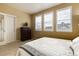 Comfortable bedroom with three windows, plush carpeting, and built-in shelving at 9711 W Indore Dr, Littleton, CO 80128