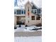 Townhouse exterior with front porch and snowy landscaping at 9711 W Indore Dr, Littleton, CO 80128