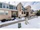 Townhouse exterior with front porch and snowy landscaping at 9711 W Indore Dr, Littleton, CO 80128