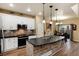 Modern kitchen with white cabinets, a large island, and stainless steel appliances at 9711 W Indore Dr, Littleton, CO 80128