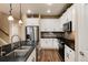 Modern kitchen with white cabinets, a large island, and stainless steel appliances at 9711 W Indore Dr, Littleton, CO 80128