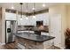 Modern kitchen with white cabinets, a large island, and stainless steel appliances at 9711 W Indore Dr, Littleton, CO 80128