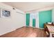 Bright bedroom featuring wood floors, a large closet, and an accent wall at 7695 E Quincy Ave # 105, Denver, CO 80237