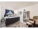 Cozy bedroom featuring a stylish gray bed frame, wood-look flooring and white walls at 7695 E Quincy Ave # 105, Denver, CO 80237