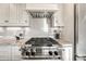 Stainless steel gas cooktop with modern range hood and granite countertops at 2 Garfield St # B, Denver, CO 80206