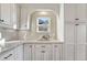 Kitchen detail showing white cabinets, granite countertops, and a charming arched window at 2 Garfield St # B, Denver, CO 80206