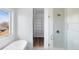 Modern bathroom featuring a glass shower with gold hardware, a soaking tub and a walk-in closet at 5392 Lions Paw St, Castle Rock, CO 80104