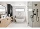 Bright bathroom features a modern tub, frameless glass shower and sleek vanity at 5392 Lions Paw St, Castle Rock, CO 80104