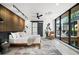 Modern bedroom with a wood accent wall, floor to ceiling windows, and a sliding barn door at 5392 Lions Paw St, Castle Rock, CO 80104