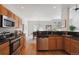 Bright kitchen with wood cabinets, stainless steel appliances, and a view into the dining room at 12860 E Dickensen Pl, Aurora, CO 80014