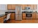 Well-equipped kitchen with stainless steel appliances and wooden cabinetry at 12860 E Dickensen Pl, Aurora, CO 80014