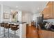 Well-lit kitchen featuring a breakfast bar, stainless steel appliances, and wooden cabinets at 12860 E Dickensen Pl, Aurora, CO 80014