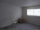 Cozy bedroom featuring neutral paint and a bright window at 10211 Ura Ln # 101, Thornton, CO 80260