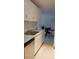 Galley kitchen with white cabinetry, stone countertops, and stainless steel appliances at 10211 Ura Ln # 101, Thornton, CO 80260