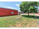 Lawn and shady tree in grassy backyard with large garage, shed, and fencing at 11085 Clarkson St, Northglenn, CO 80233