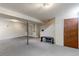 Finished basement area with carpet, storage shelves, a bench, stairs, and access door at 11085 Clarkson St, Northglenn, CO 80233