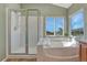 Inviting bathroom featuring a soaking tub, shower, and mountain views from the window at 17050 Park Trail Dr, Monument, CO 80132