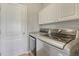 Modern laundry room featuring white cabinets and silver appliances at 17050 Park Trail Dr, Monument, CO 80132
