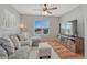 Inviting living room with large window, comfortable gray sofa, and entertainment center on hardwood floors at 17050 Park Trail Dr, Monument, CO 80132