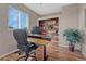 Home office with hardwood floors, custom desk, shelving, and comfortable chair at 17050 Park Trail Dr, Monument, CO 80132