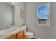 Cozy powder room with a wood vanity, neutral color palette, and window view at 17050 Park Trail Dr, Monument, CO 80132