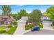 Aerial view of a well-maintained single Gathering home with lush landscaping, driveway and a blue Jeep parked nearby at 1181 E 130Th Pl, Thornton, CO 80241