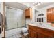 Bathroom with a shower-tub combination, wooden vanity, and ample natural light at 1181 E 130Th Pl, Thornton, CO 80241