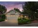Charming single-story home with a well-maintained lawn, mature trees and two-car garage, bathed in the warm light of dusk at 1181 E 130Th Pl, Thornton, CO 80241