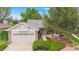 Daytime view of the attractive home with brick accents, a two-car garage and landscaped front yard at 1181 E 130Th Pl, Thornton, CO 80241