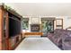 Cozy living room featuring hardwood floors, a brick fireplace, comfortable seating, and access to the outdoors at 1181 E 130Th Pl, Thornton, CO 80241